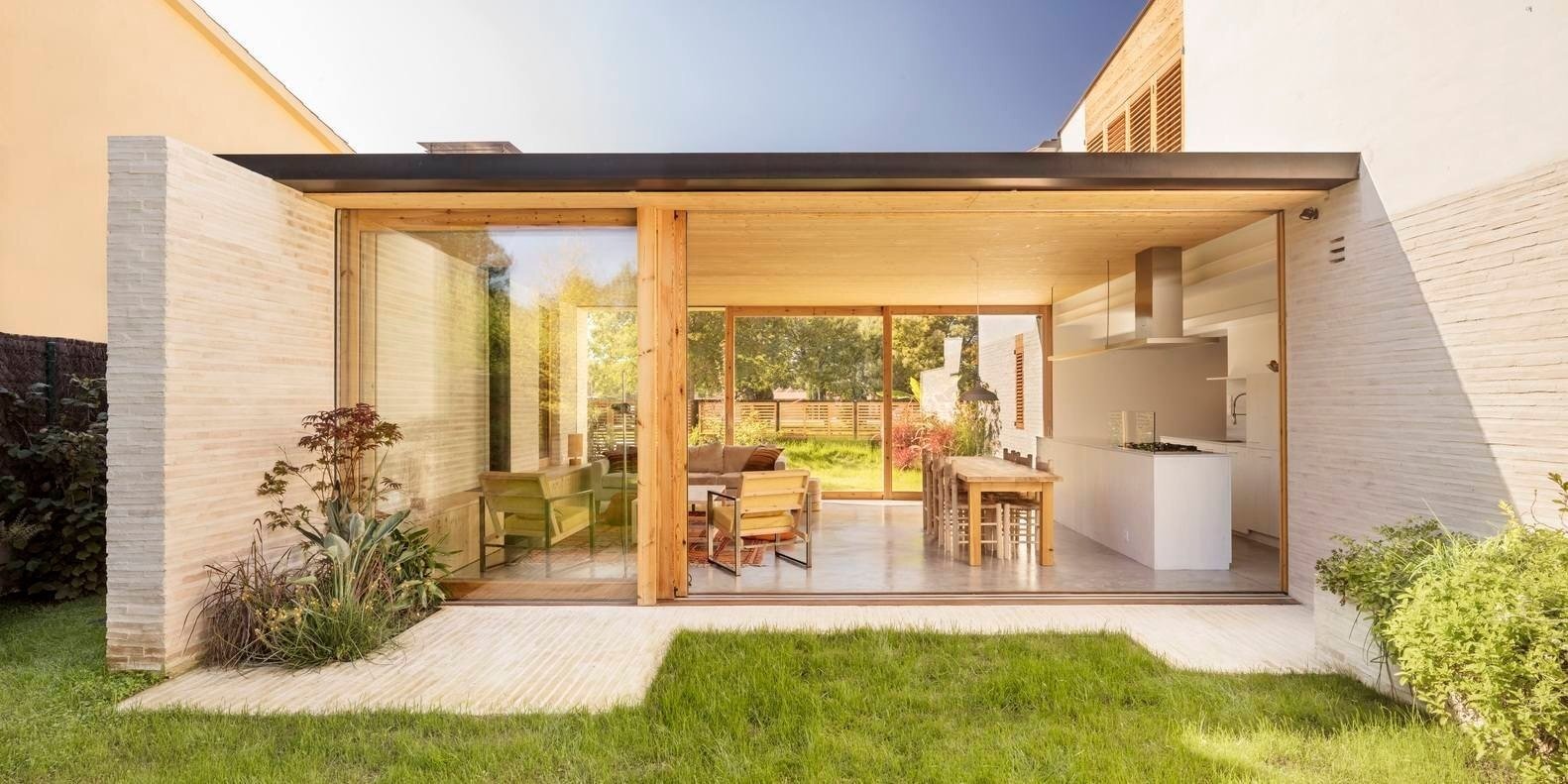A transparent horizontal volume forms the heart of the home, with sliding glass walls opening to the garden on both sides.