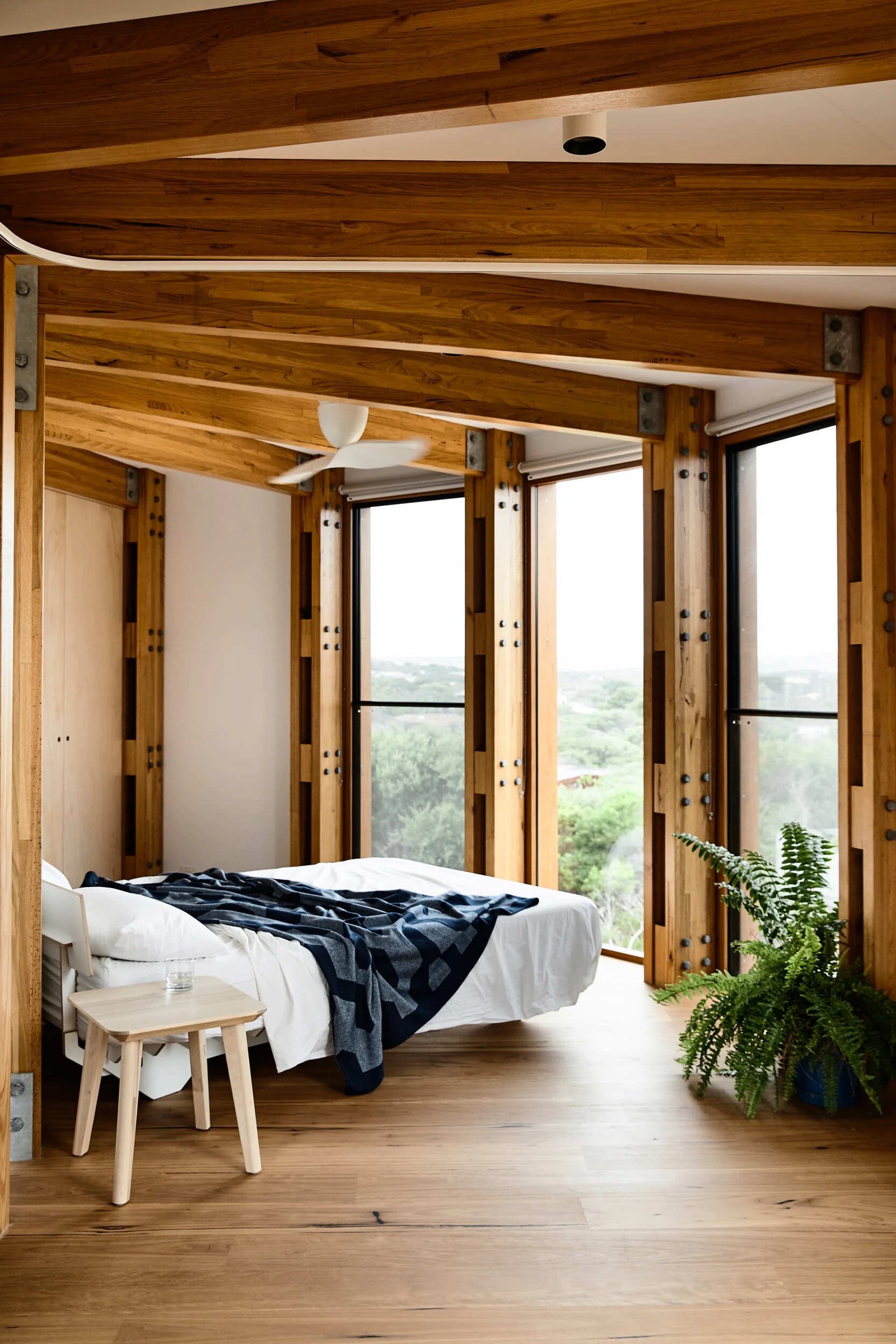A bedroom and a flexible bunk room with curtain dividers inside a compact circular holiday home.