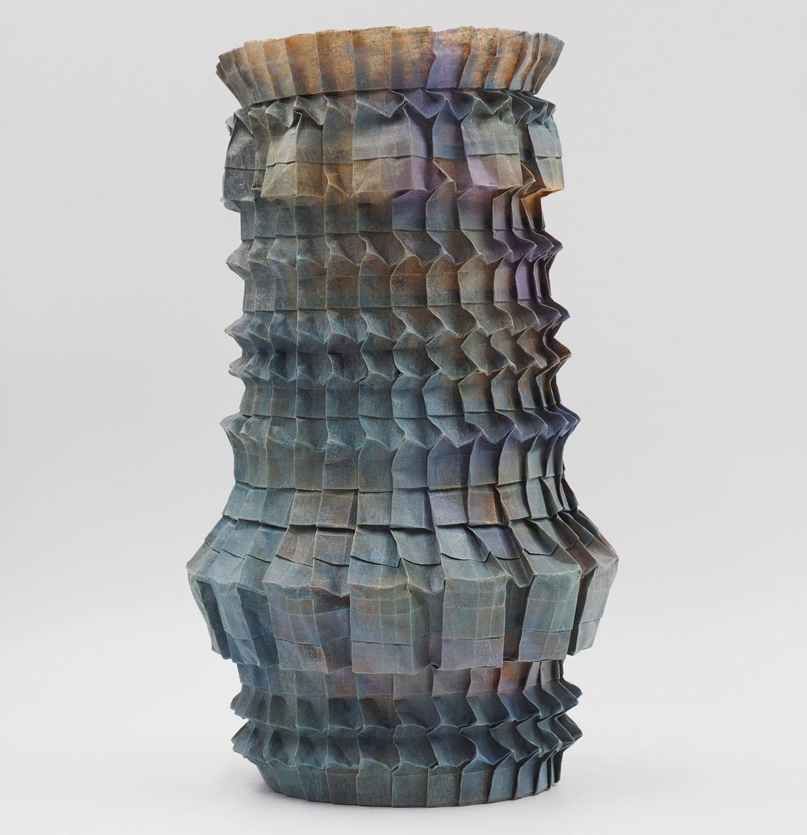 An origami paper vase with a nuanced gradient of grays and pinks