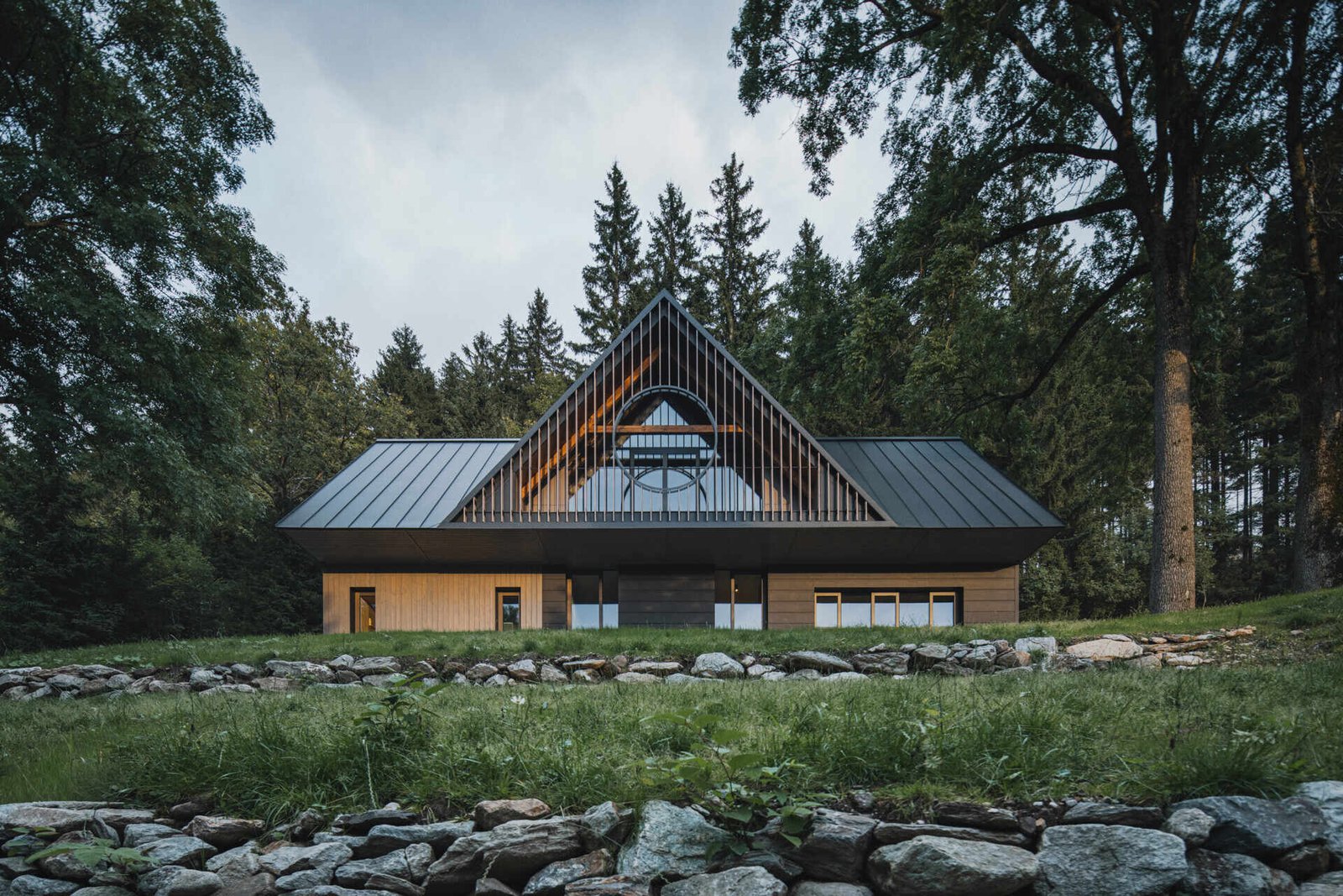 Traditional mountain cottage with steep roofs, stone bases, and timber gables blending authentic design with modern simplicity.