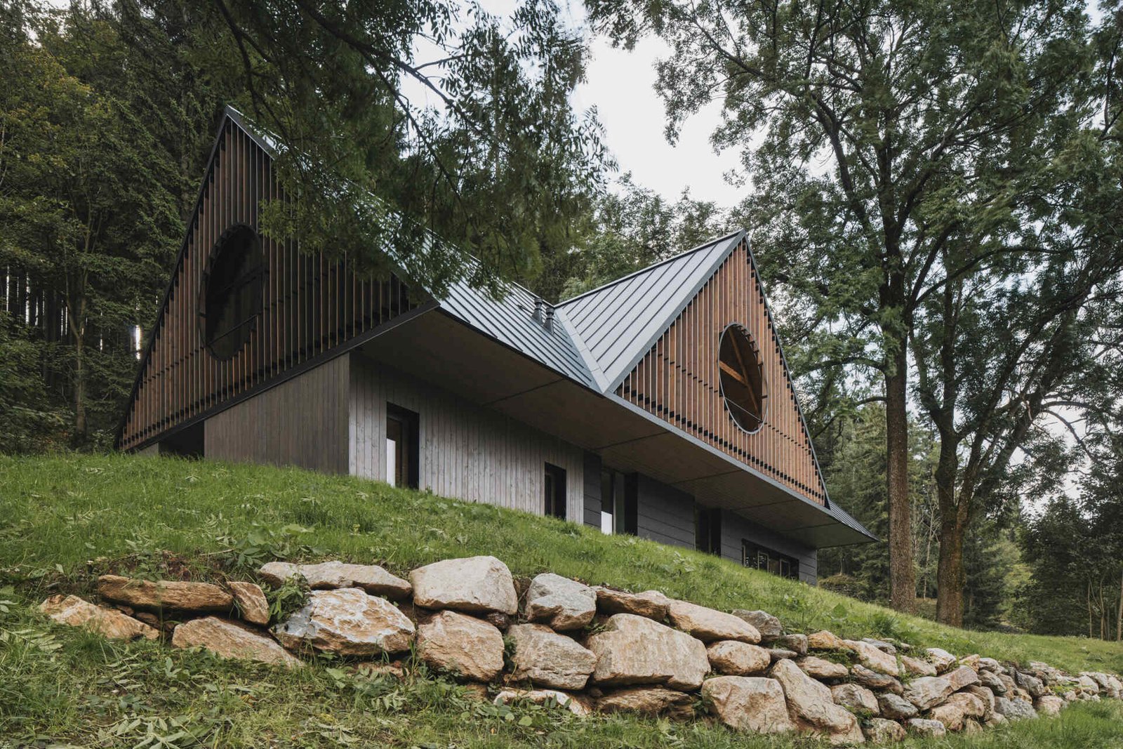Traditional mountain cottage with steep roofs, stone bases, and timber gables blending authentic design with modern simplicity.