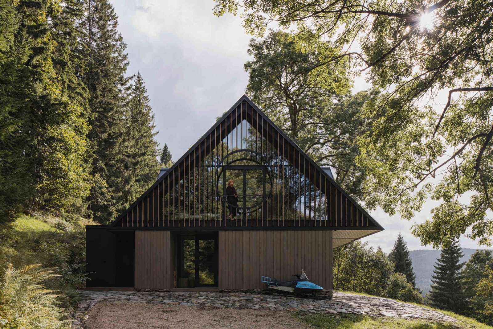 Traditional mountain cottage with steep roofs, stone bases, and timber gables blending authentic design with modern simplicity.