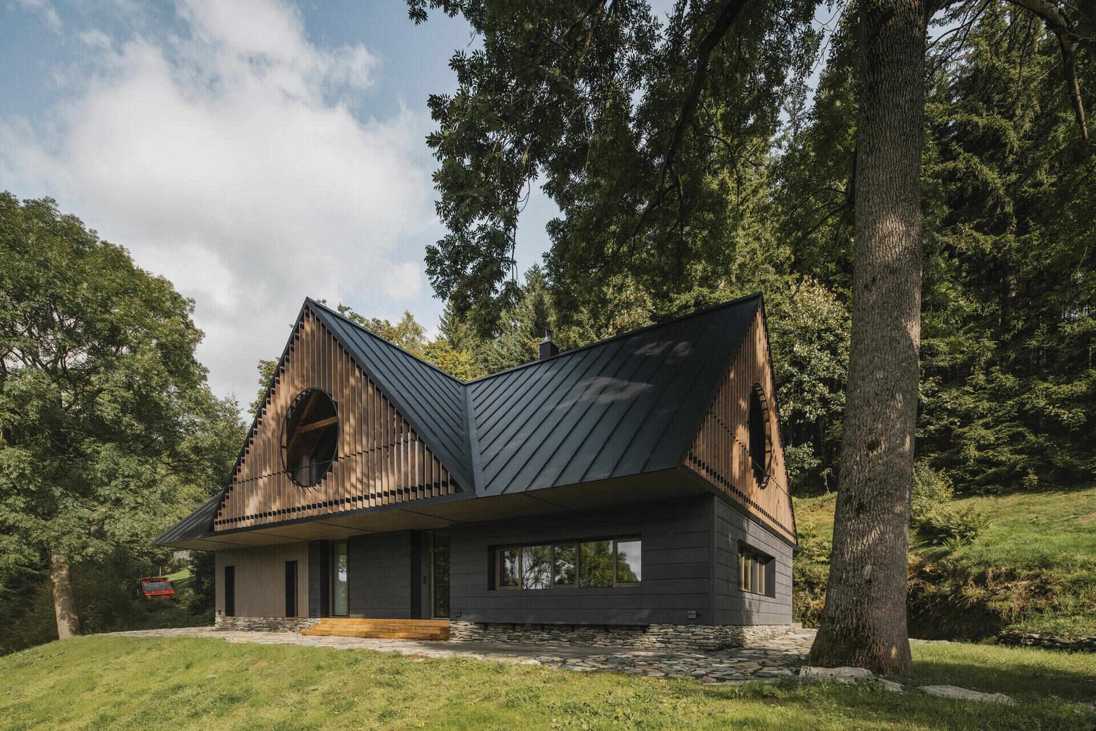 Traditional mountain cottage with steep roofs, stone bases, and timber gables blending authentic design with modern simplicity.