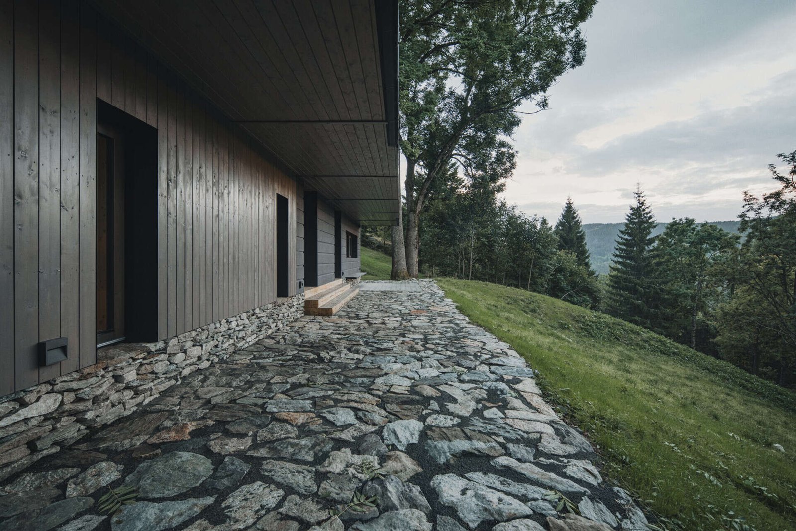 Traditional mountain cottage with steep roofs, stone bases, and timber gables blending authentic design with modern simplicity.