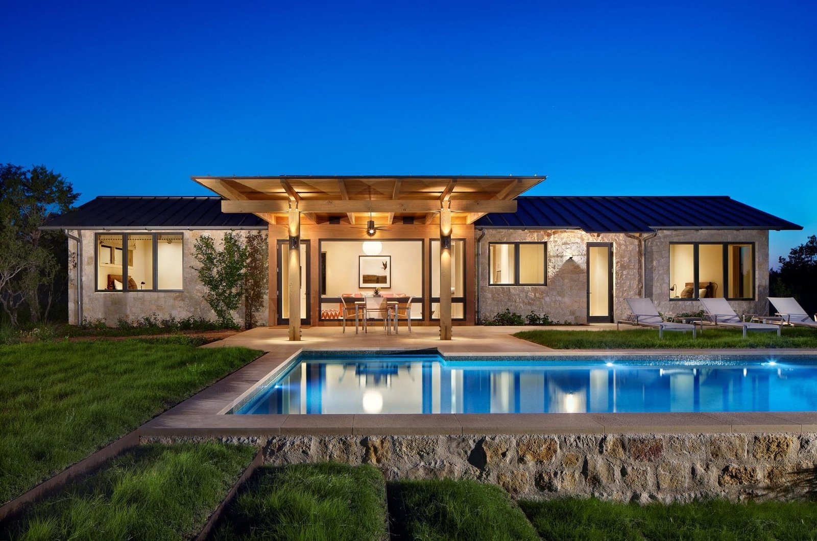 A limestone guest house by the pool features an open-plan layout with two bedrooms, offering a private yet connected space for visitors.
