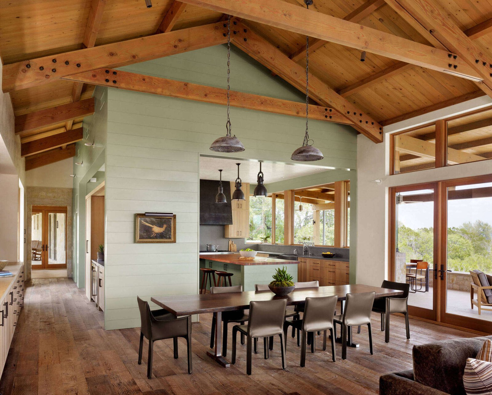 A unique kitchen designed as a wood-clad structure within the main living space, paired with a dining area and a tucked-away bar.