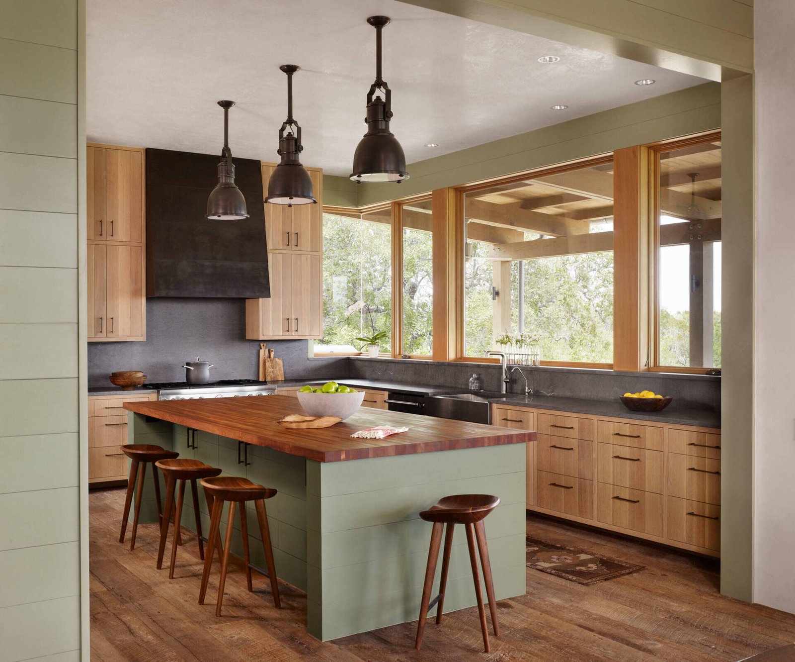 A unique kitchen designed as a wood-clad structure within the main living space, paired with a dining area and a tucked-away bar.