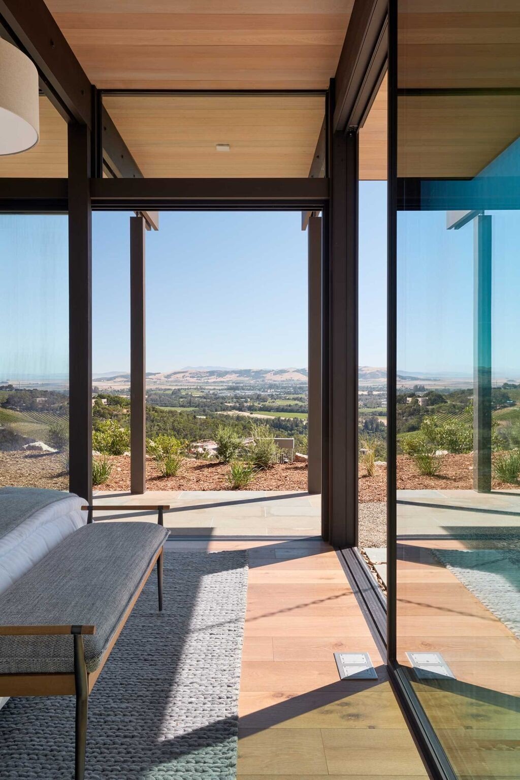 Private bedroom suites feature seating areas, valley views, and direct outdoor access through large sliding glass doors.