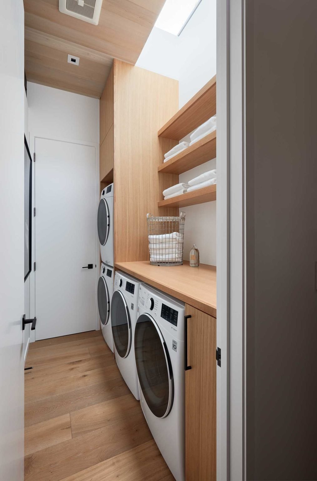 Custom cabinetry and a skylight elevate the laundry room, proving that functional spaces can be beautiful too.