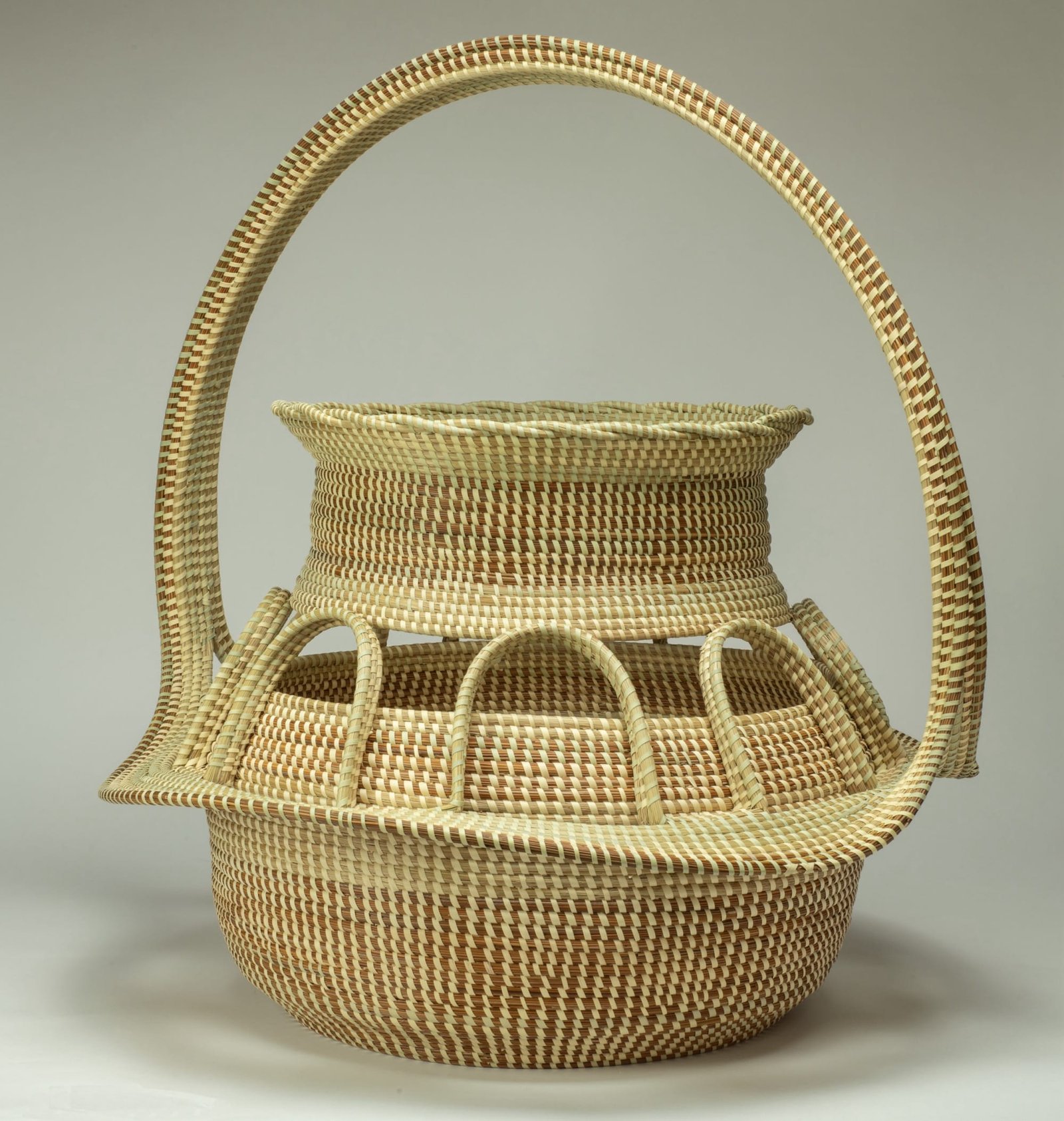 an elaborate basket with a tall handle, woven from sweetgrass