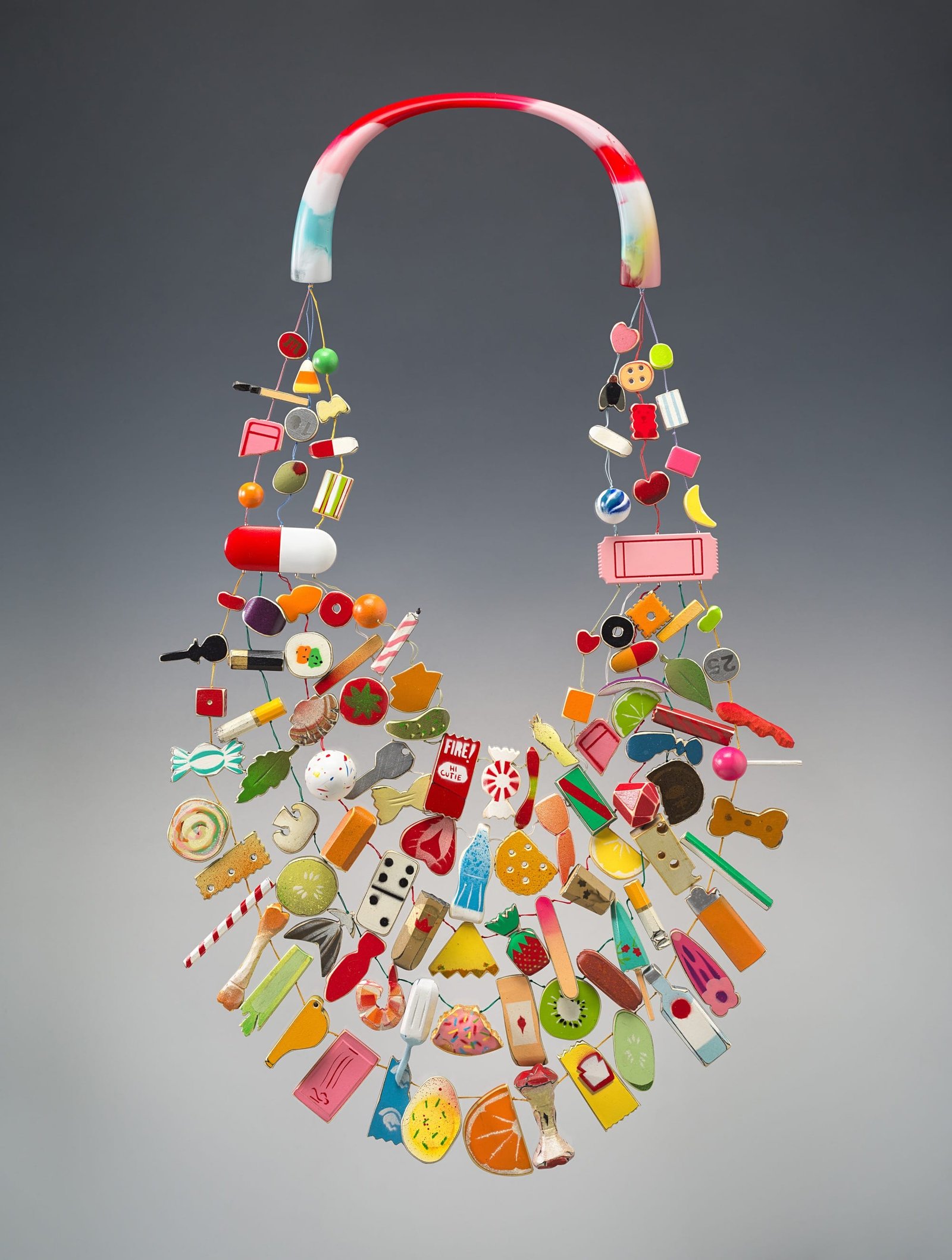 a necklace with numerous resin pieces depicting objects like dominos, snacks, bottles, and more