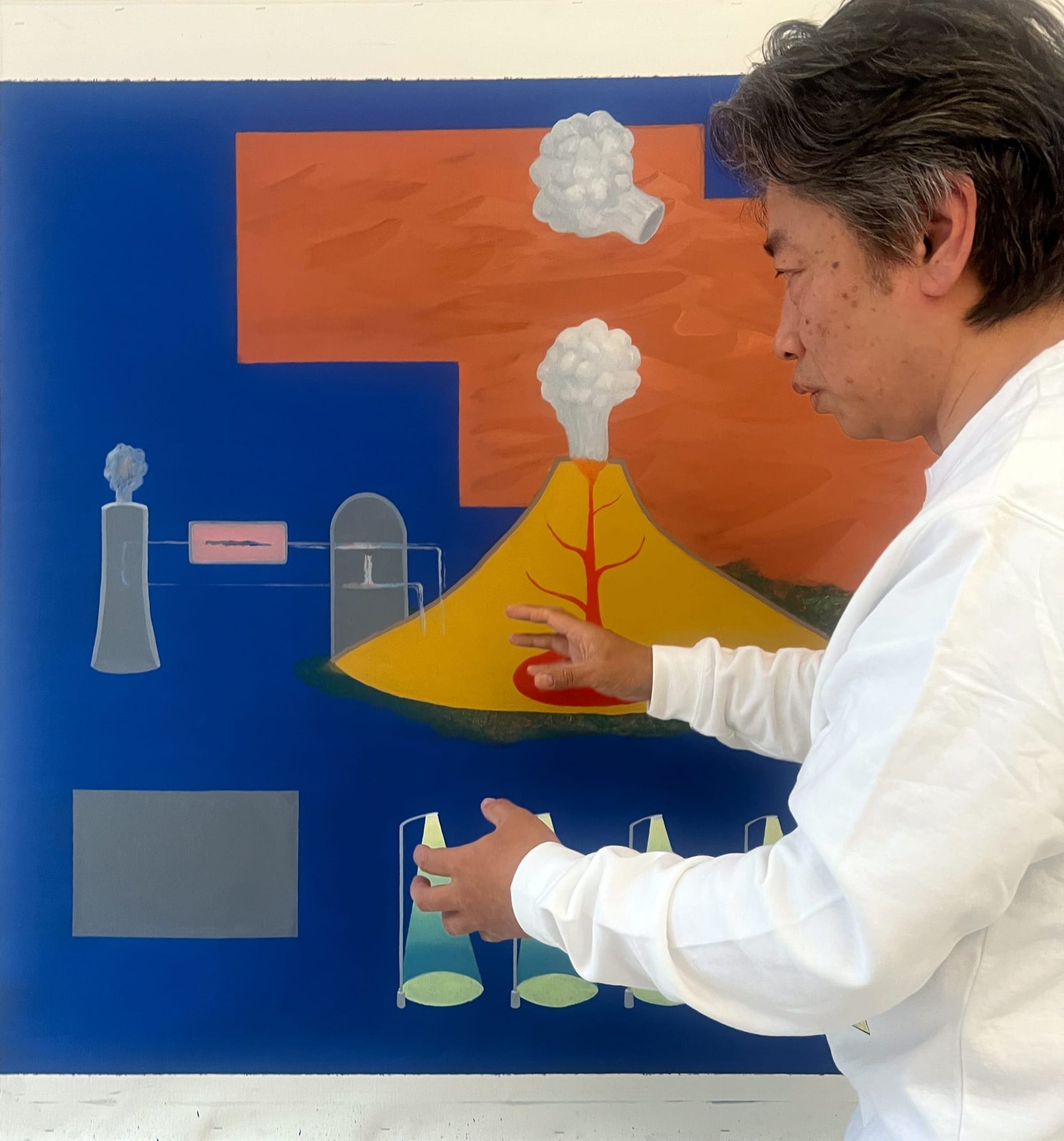 Akira Ikezoe standing in front of a blue painting in progress
