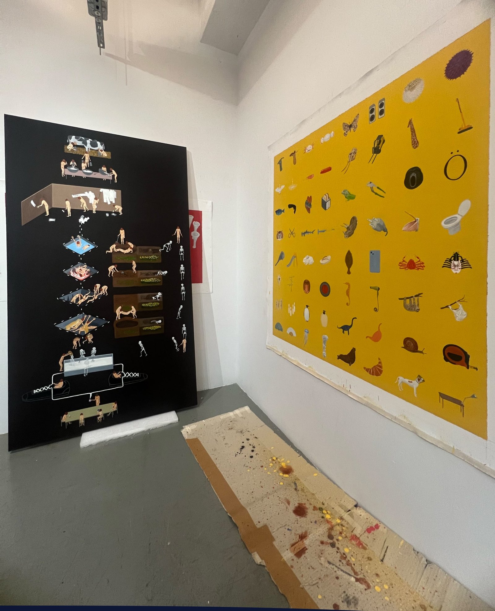 Paintings leaning on and attached to the studio wall