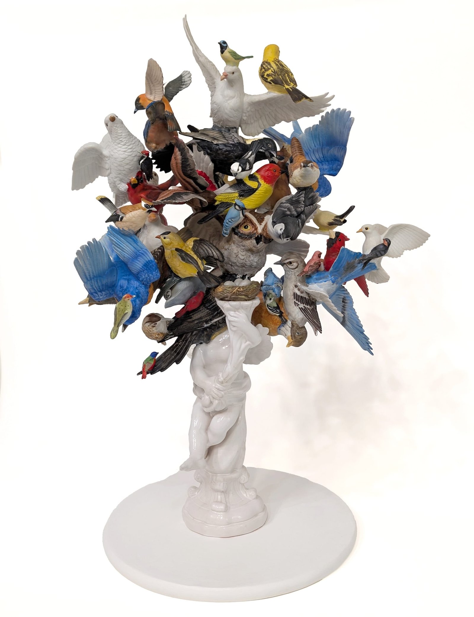 a ceramic sculpture made using numerous found ceramic bird figurines, assembled together in a jumbled composition