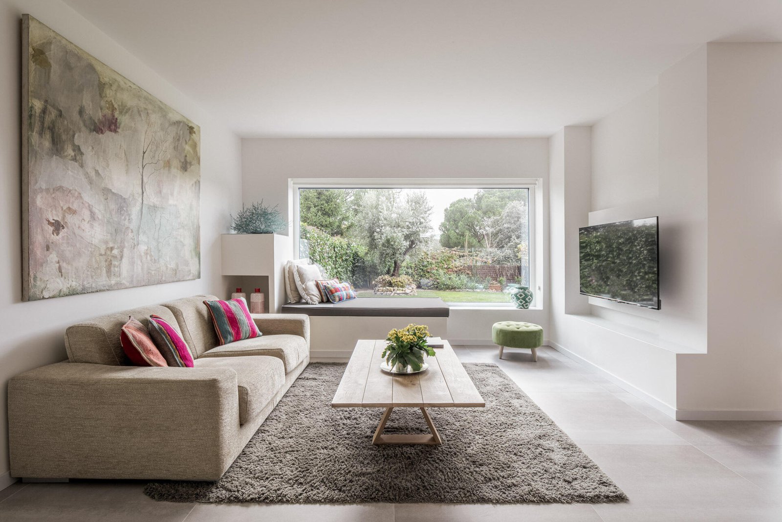 تشترك غرفة المعيشة في الجانب المواجه للحديقة من D + A House، مع تشطيبات بيضاء وأرضيات فاتحة وأبواب زجاجية منزلقة مخفية تساعد في الحفاظ على المخطط المفتوح.