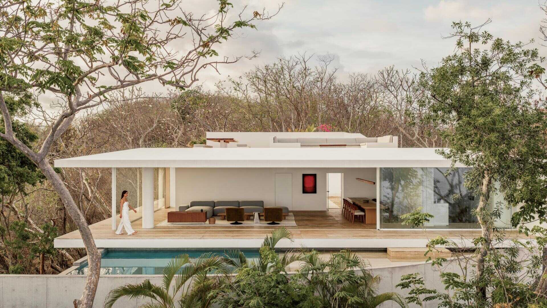 Casa Malonic in Zihuatanejo, Mexico, designed by HW Studio, uses white walls, sandy floors, shade and simple architectural forms to create a home shaped by the surrounding sea and jungle.