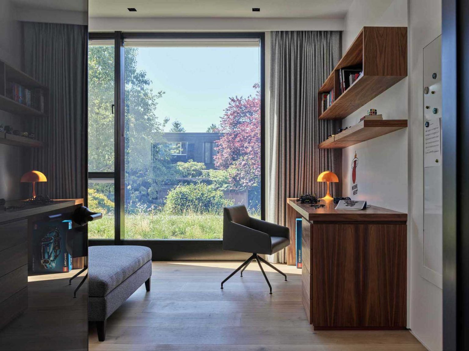 تحتوي غرفتي النوم في Nanton House على مكاتب مدمجة، مما يخلق مناطق مخصصة للدراسة ضمن التصميمات الداخلية الدافئة والمعاصرة لهذا المنزل متعدد الأجيال في فانكوفر.